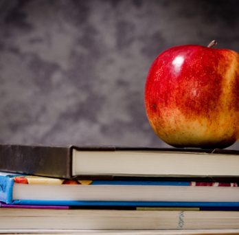 an apple on top of a stack of books 